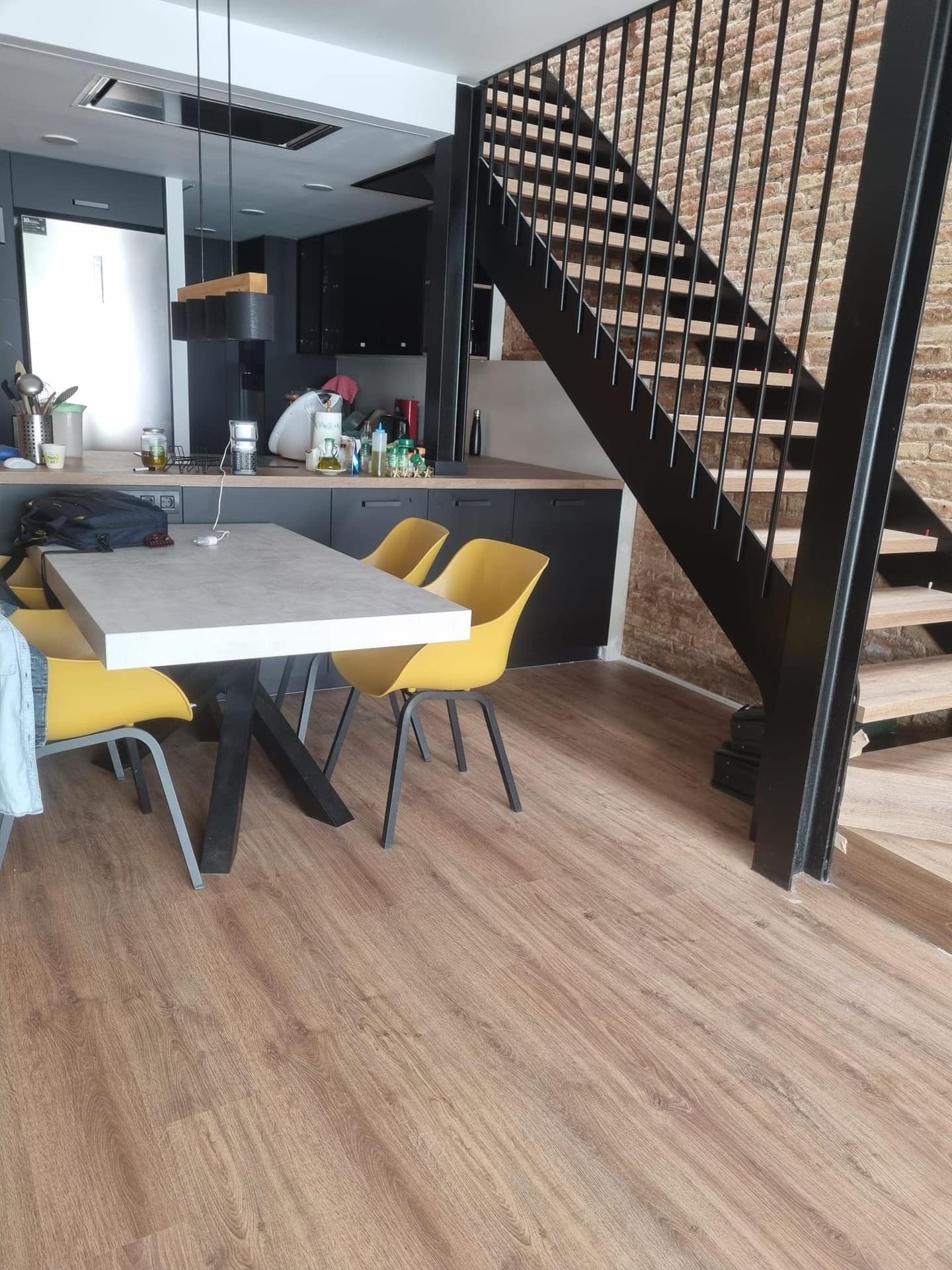 Loft moderno con suelo de parquet y escalera de madera en Barcelona